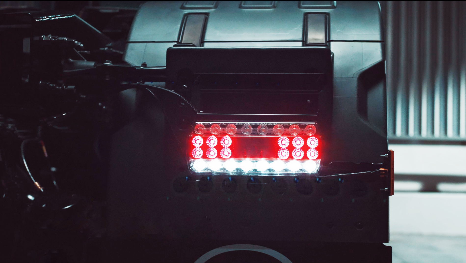 Close-up of a machine with red and white LED lights in a dimly lit room.