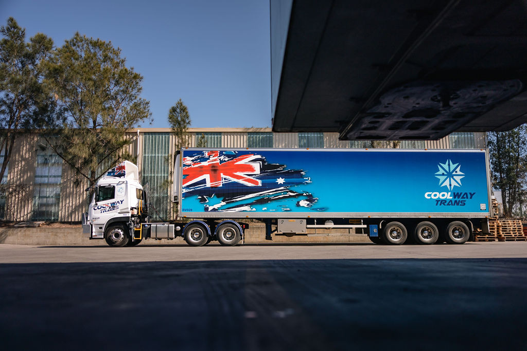 Semi-trailer truck with Australian flag livery parked near a building.