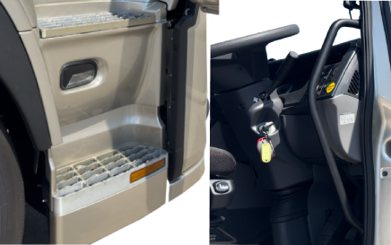 Truck entry steps and part of cabin interior with steering wheel and ignition key.